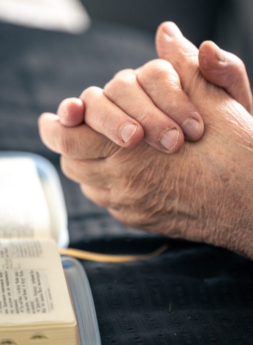 Alte Person betet in einem Gottesdienst in der Kapelle des St.Vinzenz