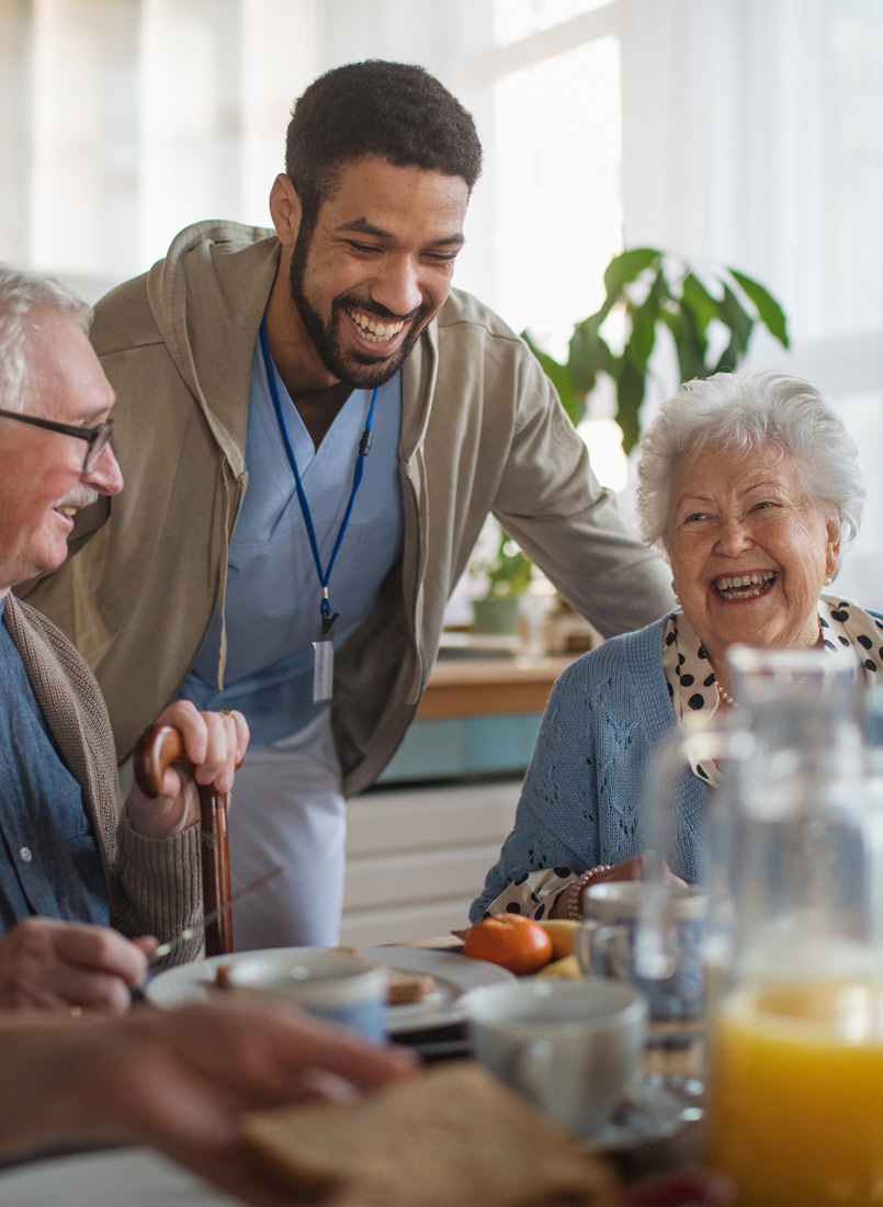 Pfleger mit Senioren am offenen Mittagstisch im Pflegeheim St.Vinzenz